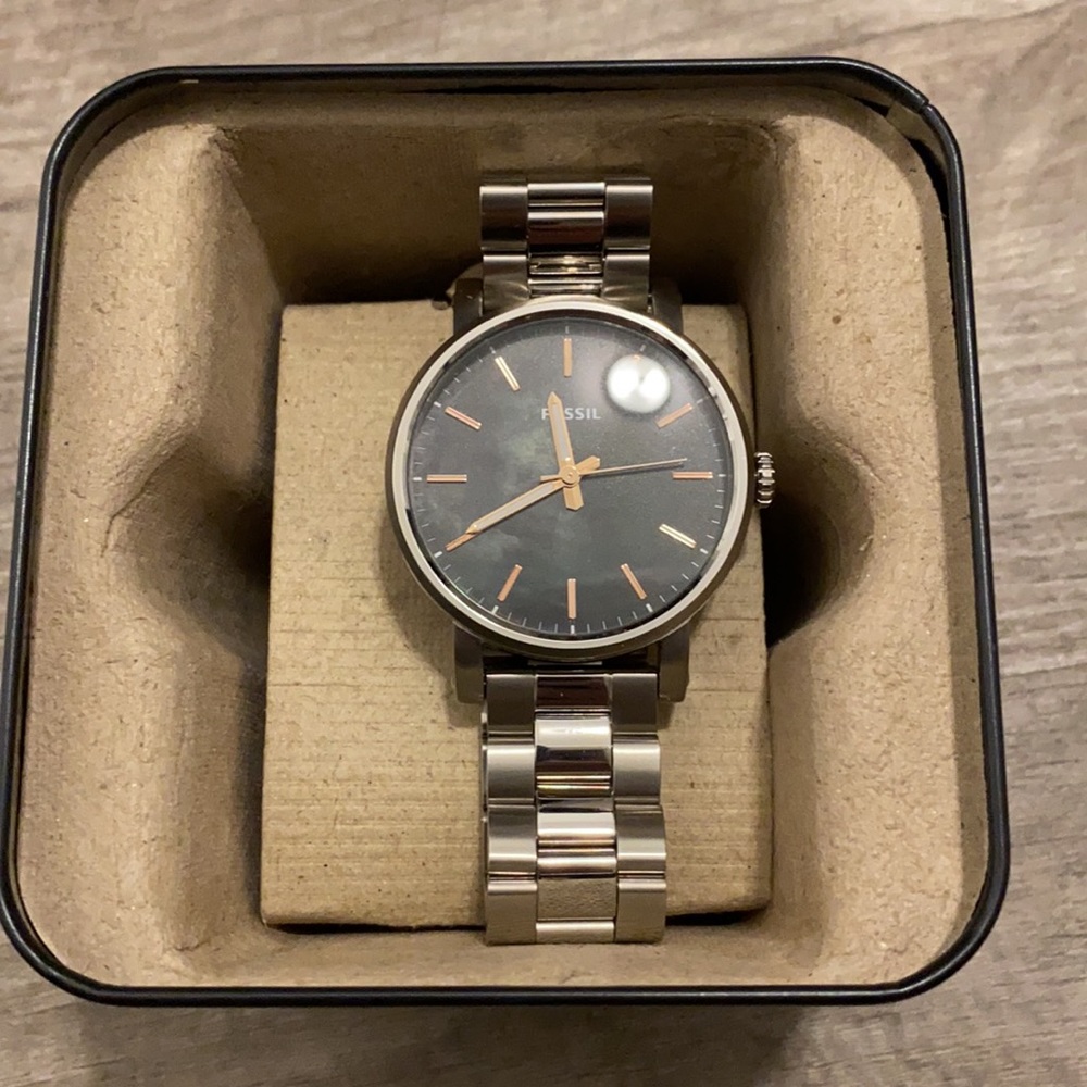 Women’s fossil watch. Silver band with black watch face. Gold/white hands.